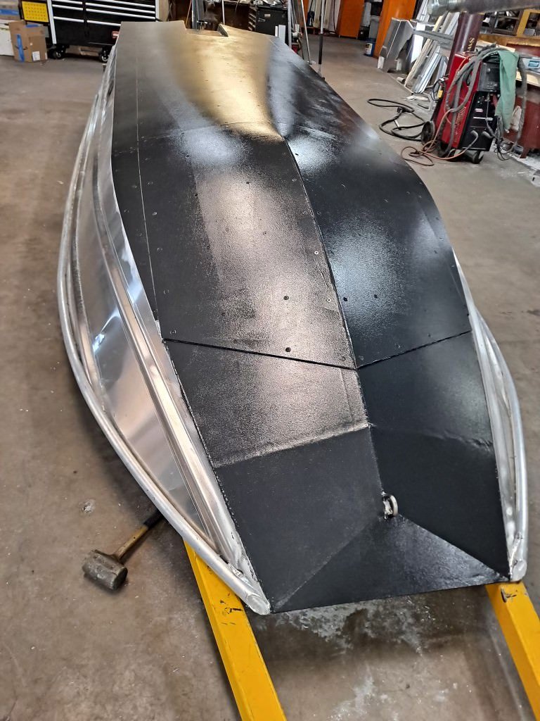 A Banshee hull upside down in the shop with the armored bottom finished in a black coating